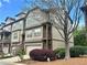Townhome with a two-car garage, a small porch, and manicured landscaping at 702 Emeril Dr, Avondale Estates, GA 30002