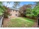 Expansive backyard with lush green lawn, mature trees, and a charming brick home with a deck overlooking the yard at 2790 Westhampton Way, Tucker, GA 30084