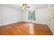 A bright bedroom with hardwood floors, a ceiling fan, and a window dressed with patterned blue curtains at 2790 Westhampton Way, Tucker, GA 30084