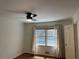 An empty bedroom with hardwood floors, a ceiling fan, and a window with blinds and light-colored curtains at 2790 Westhampton Way, Tucker, GA 30084