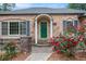 Brick home with a green front door framed by columns and vibrant red roses at 2790 Westhampton Way, Tucker, GA 30084