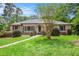 Charming brick home featuring a lush green lawn, mature trees, and colorful landscaping at 2790 Westhampton Way, Tucker, GA 30084