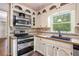 Close-up shot of kitchen featuring stainless steel oven, microwave, and sink with window view at 2790 Westhampton Way, Tucker, GA 30084