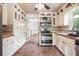 Charming kitchen features white cabinets, stainless steel appliances, and a tiled backsplash at 2790 Westhampton Way, Tucker, GA 30084
