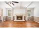Large living room with hardwood floors, fireplace, ceiling fan, and large windows at 2790 Westhampton Way, Tucker, GA 30084