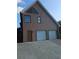 Exterior view of a home featuring a three-car garage, a door, and brown siding at 4299 Sherwood Oaks Dr, Decatur, GA 30034
