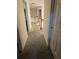 Well-lit hallway with neutral carpet, white walls, and stairs visible in the distance at 4299 Sherwood Oaks Dr, Decatur, GA 30034
