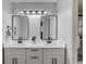 A bathroom with a double sink, white cabinets, black fixtures, and large mirrors at 1728 Hudson Rd, Decatur, GA 30033