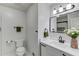 A bathroom with white cabinets, black hardware, a black faucet, and a large vase of flowers at 1728 Hudson Rd, Decatur, GA 30033