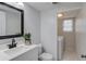 A modern bathroom with white vanity, black hardware, and tiled flooring at 1728 Hudson Rd, Decatur, GA 30033