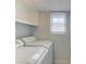 Practical laundry room with white appliances, shelving, and a window for natural light at 1728 Hudson Rd, Decatur, GA 30033
