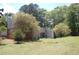 Large, grassy backyard with mature trees and a brick chimney, offering a peaceful outdoor space at 3215 Hembry Ct, Marietta, GA 30062