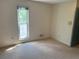 An empty bedroom with neutral carpet, wallpaper, one window, and a closet door at 3215 Hembry Ct, Marietta, GA 30062