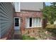 View of the side of the home featuring a brick facade, large window, and side entry door at 3215 Hembry Ct, Marietta, GA 30062