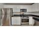 Modern kitchen with stainless steel appliances, granite countertops, and white cabinets, offering a clean and efficient cooking space at 829 Longfellow Ct, Stone Mountain, GA 30088