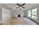 Spacious living room with a cozy fireplace, ceiling fan, large window, and durable wood-look floors for comfort and style at 829 Longfellow Ct, Stone Mountain, GA 30088