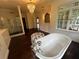 Bright primary bathroom featuring a soaking tub, chandelier, and marble topped vanity at 2038 Lee Se Rd, Smyrna, GA 30080