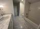 Bright bathroom with marble countertop vanity, grey hexagon tile flooring, and walk-in shower at 2038 Lee Se Rd, Smyrna, GA 30080