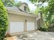 Attached two-car garage with white doors and exterior lighting at 2038 Lee Se Rd, Smyrna, GA 30080