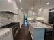 Bright open kitchen features stainless steel appliances, marble countertops, island with seating and wood floors at 2038 Lee Se Rd, Smyrna, GA 30080