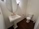Elegant powder room showcasing a pedestal sink with gold hardware and oval mirror at 2038 Lee Se Rd, Smyrna, GA 30080