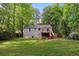 View of the backyard with a deck leading to the grassy lawn and mature trees at 2599 E Tupelo Se St, Atlanta, GA 30317