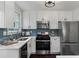 Modern kitchen with stainless steel appliances, white cabinets, quartz counters, and a subway tile backsplash at 2599 E Tupelo Se St, Atlanta, GA 30317