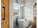 Bathroom showing soaking tub with natural light and a modern wood door with handle at 3846 Chattahoochee Summit Se Dr # 31, Atlanta, GA 30339