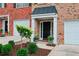 Entrance to the townhome with a covered porch, green landscaping and an attached garage at 3846 Chattahoochee Summit Se Dr # 31, Atlanta, GA 30339
