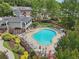 Resort-style pool surrounded by ample seating, mature landscaping, and community clubhouse at 3846 Chattahoochee Summit Se Dr # 31, Atlanta, GA 30339