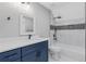 Bathroom with blue vanity, white countertops, and a white tiled shower and tub at 470 Brackin Trce, Grayson, GA 30017