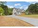 View of home with a long driveway leading to a garage and a covered front porch at 470 Brackin Trce, Grayson, GA 30017
