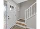 Entryway with white staircase, featuring wood-look stairs and decorative glass front door at 470 Brackin Trce, Grayson, GA 30017
