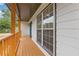 Close-up of the covered front porch featuring a warm wooden deck and supporting columns at 470 Brackin Trce, Grayson, GA 30017