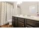 Bathroom featuring dark cabinets, double sinks, granite countertops and decorative mirror at 113 Expedition Dr, Ellenwood, GA 30294