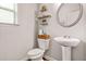 Neat half bathroom featuring toilet, sink, mirror, shelf and window at 113 Expedition Dr, Ellenwood, GA 30294