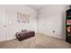 Bedroom featuring neutral walls, tan carpet, and a storage bench at 113 Expedition Dr, Ellenwood, GA 30294