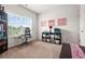 Bright bedroom featuring a window with blinds, a large bookshelf, and a work space at 113 Expedition Dr, Ellenwood, GA 30294