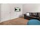 Living room featuring neutral walls, tan carpet, and a mounted flat screen TV at 113 Expedition Dr, Ellenwood, GA 30294