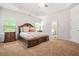 Main bedroom featuring tan carpet, neutral walls, decorative windows, and an en-suite bathroom at 113 Expedition Dr, Ellenwood, GA 30294