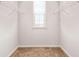Bright walk-in closet featuring neutral walls, tan carpet, wire shelving, and a window to provide natural light at 113 Expedition Dr, Ellenwood, GA 30294