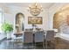 Formal dining room with an elegant beaded chandelier, brick accent wall, and view into the kitchen at 3938 Hillsman Ln, Marietta, GA 30062