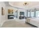 Spacious primary bedroom featuring a fireplace, tray ceiling with chandelier, and large windows at 3938 Hillsman Ln, Marietta, GA 30062