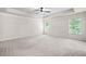 Spacious bedroom featuring a tray ceiling, ceiling fan, carpet, and lots of natural light at 4120 Cordova Ln, Cumming, GA 30028