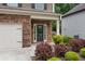Welcoming entryway with a glass-paneled front door, stone surround, and manicured landscaping at 4120 Cordova Ln, Cumming, GA 30028