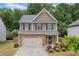 Charming two-story home featuring stone accents, a two-car garage, and a well-manicured lawn with shrubs at 4120 Cordova Ln, Cumming, GA 30028