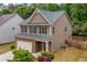 Two-story home with brown siding, a two-car garage, and a cozy, well-landscaped yard at 4120 Cordova Ln, Cumming, GA 30028