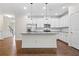 Bright and open kitchen featuring white cabinets, stainless steel appliances, granite countertops, and hardwood floors at 4120 Cordova Ln, Cumming, GA 30028