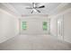 Spacious main bedroom featuring a tray ceiling, ceiling fan, carpet, and ensuite bathroom at 4120 Cordova Ln, Cumming, GA 30028
