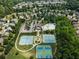 Aerial view of community with a pool, tennis courts, and well-maintained landscaping at 5830 Sterling Ct, Cumming, GA 30040